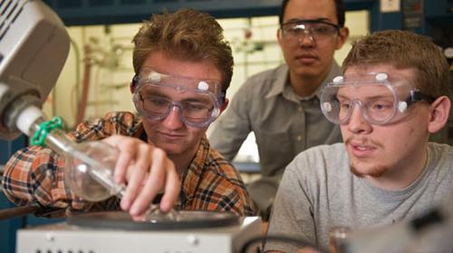 Chemistry students in lab pouring