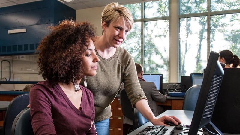 Lora Becker helping student at computer